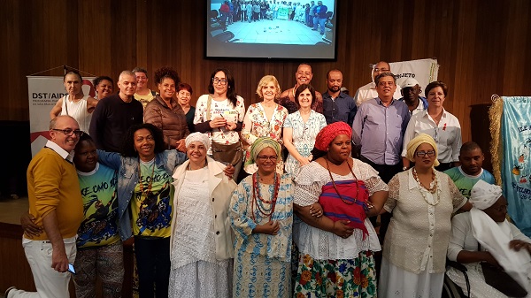 #PraCegoVer: Convidados no evento das religiões afro-brasileiras. Todos estão em pé e sorrindo, alguns estão vestidos de branco.